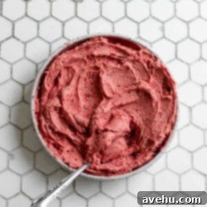 Cloud-Soft Strawberry Buttercream 2 A bowl of fluffy strawberry buttercream frosting with a natural pink color, ready for use on a white background.