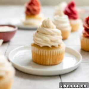 Easy Homemade Oil-Based Vanilla Cupcakes 2 A vanilla cupcake with white frosting sitting on a small white plate, ready to be enjoyed.