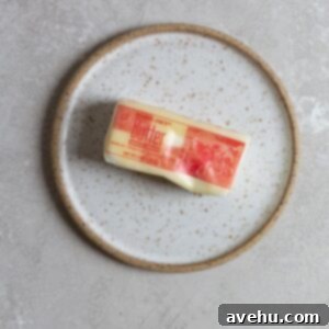 Fast Butter Softening for Perfect Texture 2 A softened stick of butter on a white plate