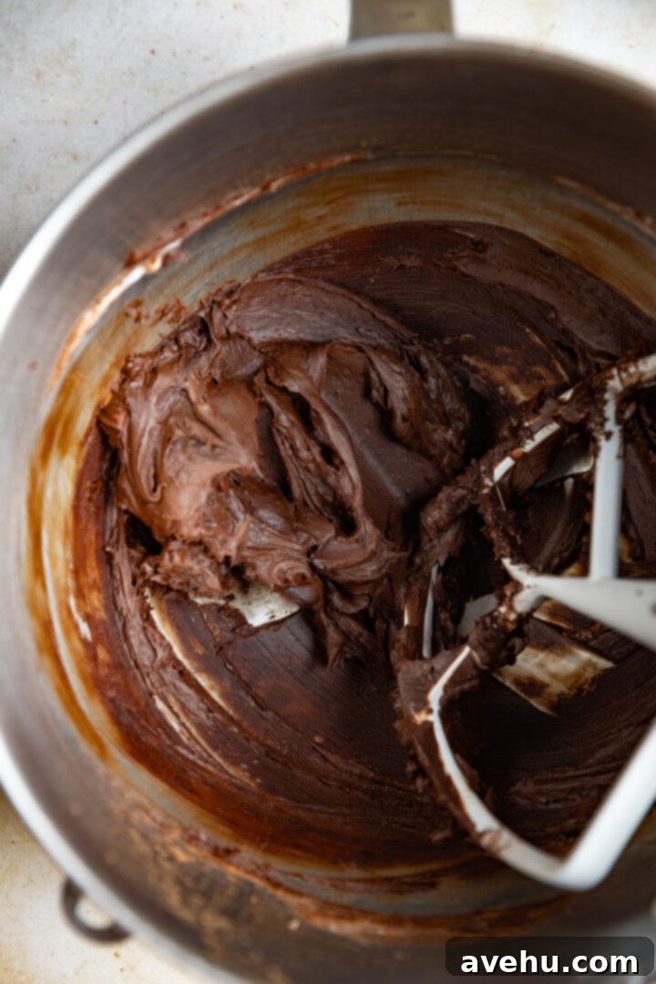 5-Minute Cocoa Chocolate Buttercream Frosting 4 Creamed softened butter and cocoa powder in a mixing bowl after initial blending, showing a smooth, cohesive mixture.