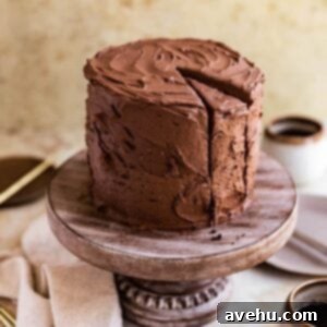 Decadent Mocha Crumb Cake 2 A slice of moist chocolate coffee cake on a wooden cake stand, revealing its rich, dark crumb and a swirl of coffee-infused frosting.