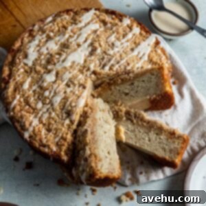 Velvet Banana Coffee Cake 2 Banana coffee cake with 2 slices cut out on a linen and cutting board.