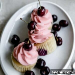 Velvet Cherry Delights 2 Three cherry cupcakes on an oval platter with fresh cherries around.