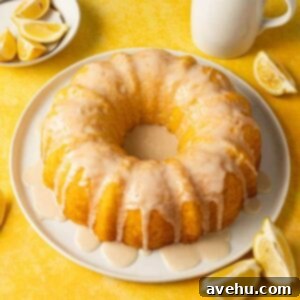 Quick & Moist Lemon Bundt Cake 4 A slice of quick lemon pudding bundt cake with a generous drizzle of glaze, served on a white plate with a bright yellow background.