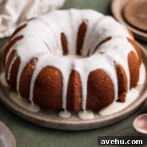 Deliciously Simple Gingerbread Bundt 2 A gingerbread bundt cake topped with a white glaze on a brown plate.