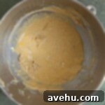 Deliciously Simple Gingerbread Bundt 4 Butter, sugar, eggs, and oil mixed in bowl.