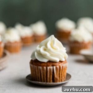 Perfectly Simple Pumpkin Cupcakes with Cream Cheese Frosting 2 A pumpkin cupcake with cream cheese frosting on a small plate.
