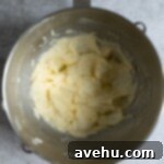 Effortless Chocolate Chip Pound Cake Without Sour Cream 3 A mixture of butter, sugar, and eggs mixed together in a bowl.