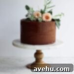 Elevate Your Cakes To Pro Level: 10 Essential Techniques 14 A chocolate cake on a marble and wood cake stand with flower decorations