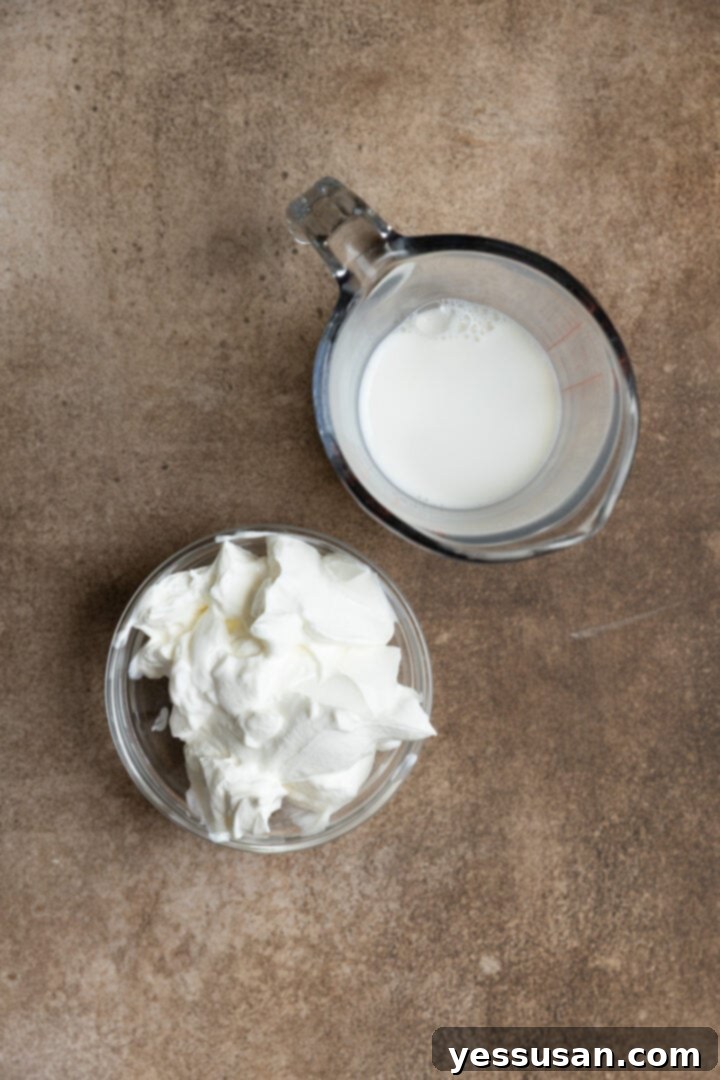 Fluffy Golden Butter Cake 5 Measured sour cream and whole milk in separate bowls on a wooden board.