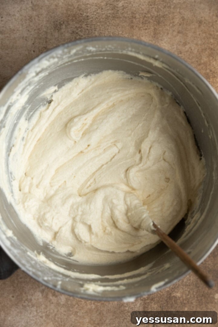 Fluffy Golden Butter Cake 6 Smooth, light yellow cake batter in a mixing bowl with the paddle attachment.