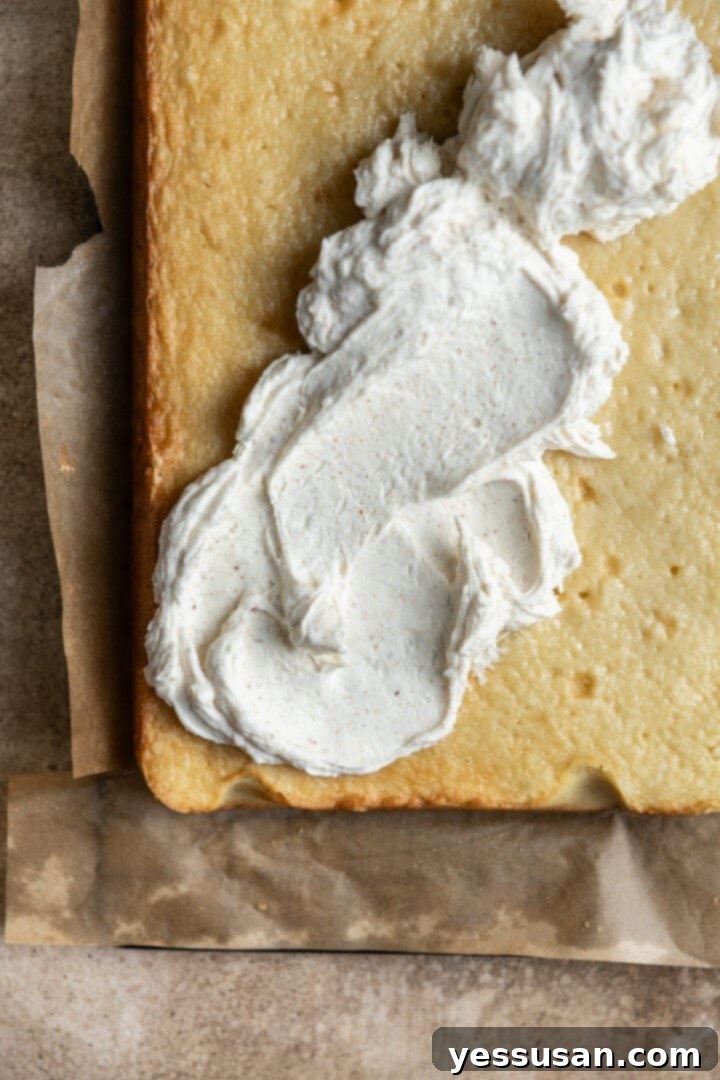 Fluffy Golden Butter Cake 9 Partially frosted 9x13 inch butter cake with luscious brown butter frosting being spread.