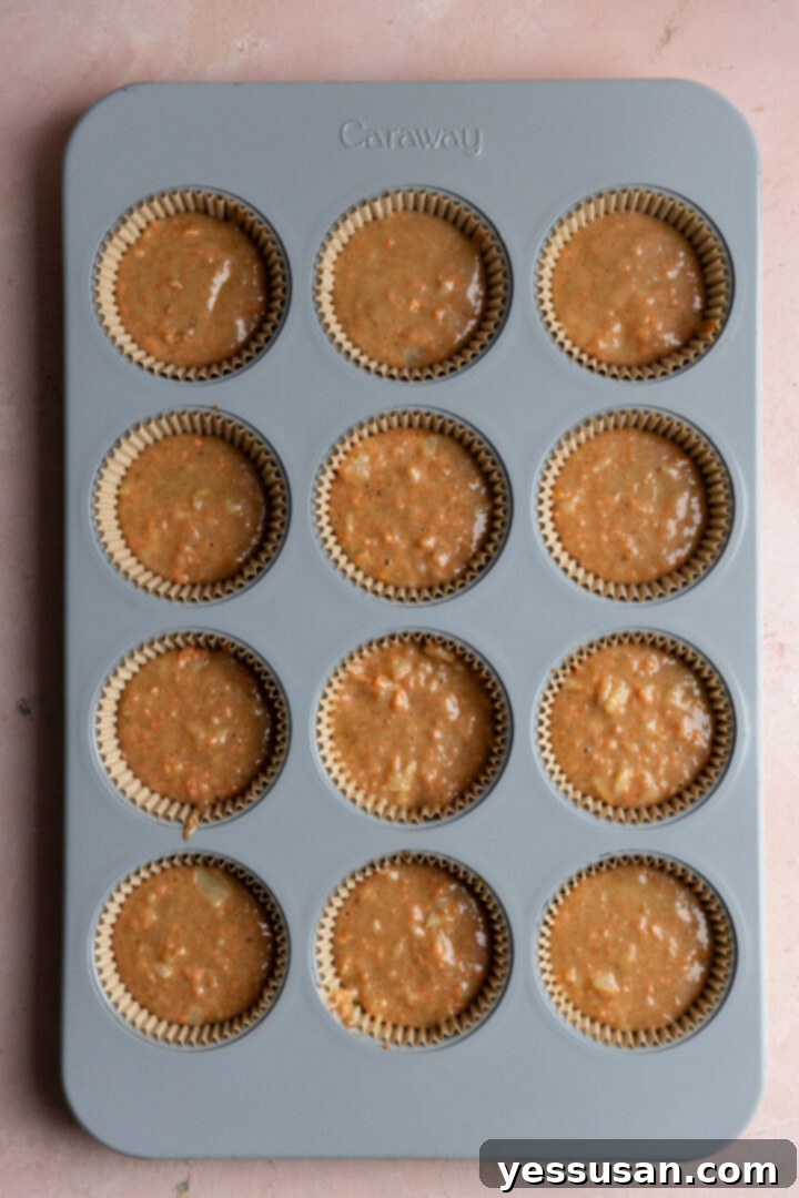 Pineapple-Packed Carrot Cupcake Delights 7 Batter scooped into lined muffin cups.