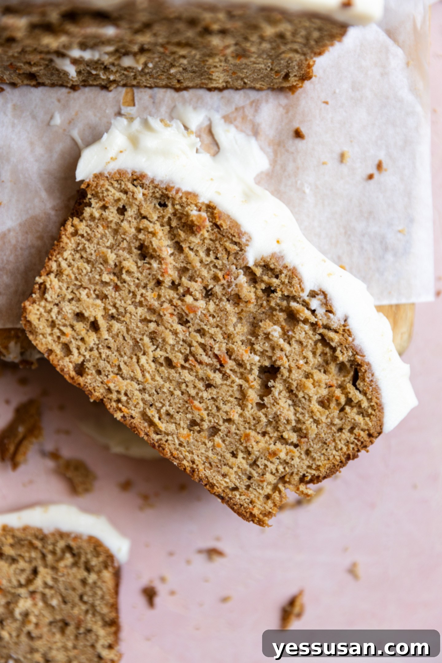 Moist Carrot Loaf: Simple Baking Perfection 9 A delectable slice of carrot cake loaf on a rustic wooden cutting board.